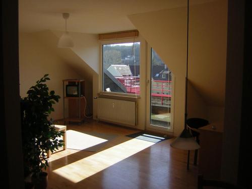 Zimmer im Dachgeschoss mit einem großen Fenster und einer Treppe in der Unterkunft Ferienwohnung Pforzheim in Pforzheim