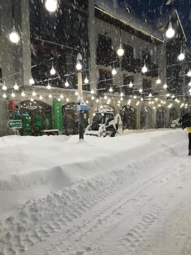 a snow covered street with a building with lights at New Gudauri Loft 2,apart 106 in Gudauri