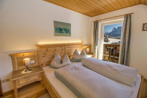 a bedroom with two beds and a window at Appartments Neuhof in Collalbo