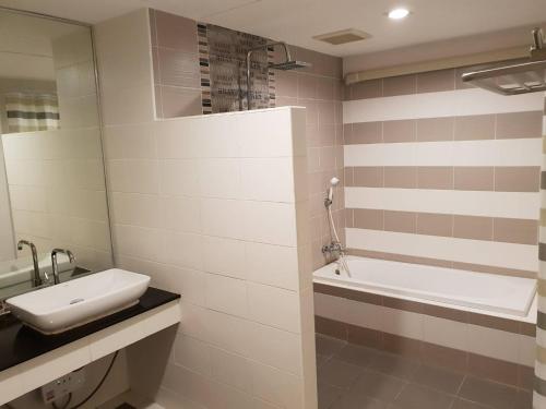 a bathroom with a sink and a bath tub at OMG Hotel in Khon Kaen