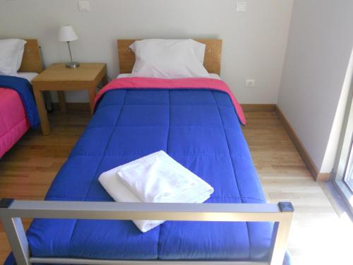 a large blue bed in a small room at Azores Youth Hostels - São Jorge in Calheta