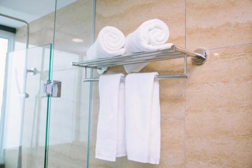 un mucchio di asciugamani su un portasciugamani in bagno di The Capital Residence Suites a Bandar Seri Begawan