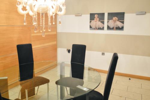 a dining room with a glass table and chairs at Posh Pads - Liverpool 1 - Apart-Hotel in Liverpool