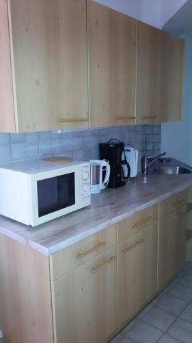a kitchen counter with a microwave on top of it at Gästehaus Tarmann in Annenheim