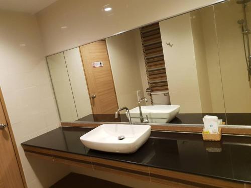 a bathroom with a sink and a large mirror at OMG Hotel in Khon Kaen