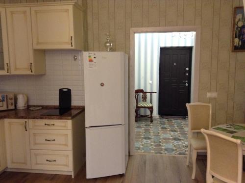 スヴェトロゴルスクにあるRauschen Apart Hotelのキッチン(白い冷蔵庫、テーブル付)