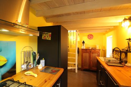 una cucina con pareti gialle e un piano di lavoro in legno di gîte papillon 4 a Civray-de-Touraine