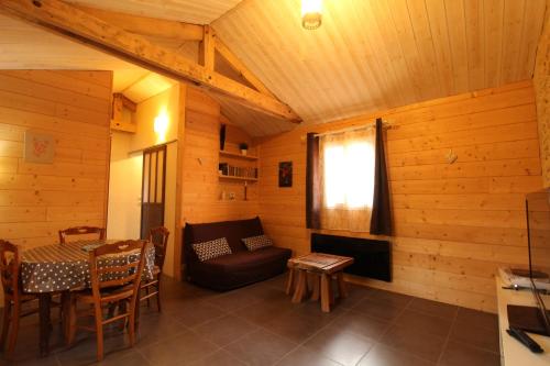 um quarto com um sofá e uma mesa numa cabina em gîte papillon 4 em Civray-de-Touraine