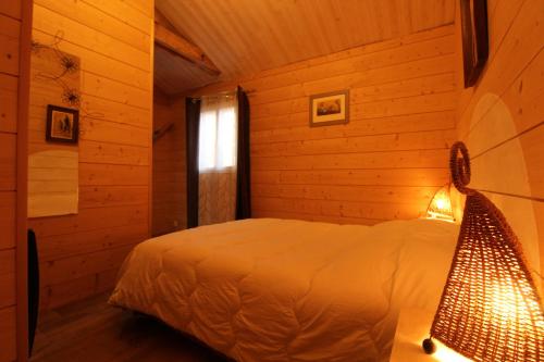 een slaapkamer met een bed in een blokhut bij gîte papillon 4 in Civray-de-Touraine