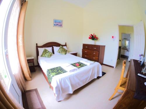 a bedroom with a bed and a dresser and a window at Azure Villa in Belle Mare