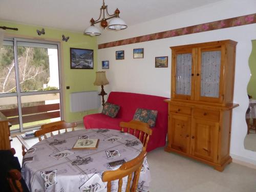 un salon avec une table et un canapé rouge dans l'établissement Les Berges Du Gave D'azun, à Argelès-Gazost