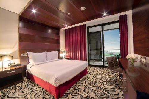 a hotel room with a bed and a desk and window at Radisson Blu Hotel, Abu Dhabi Yas Island in Abu Dhabi