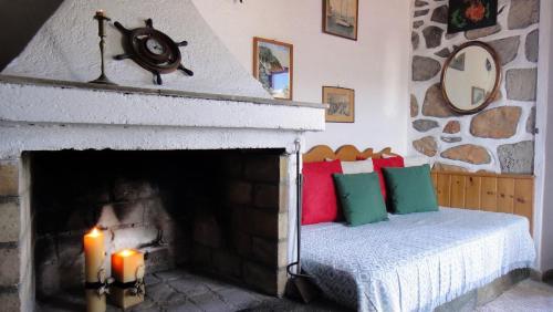 a bedroom with a fireplace with a bed and a candle at Tramontana in Hydra