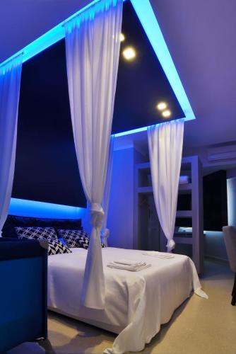 a bedroom with a white bed with blue lights at Villa La Fenice in Reggio Calabria