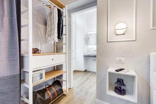 a dressing room with a closet with white cabinets at Opera Private Suites by Premium Suites Collection in Rome