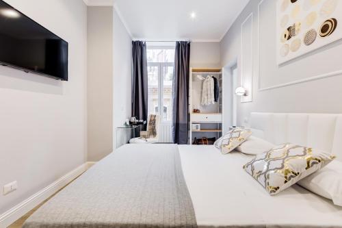 a white bedroom with a large bed and a flat screen tv at Opera Private Suites by Premium Suites Collection in Rome
