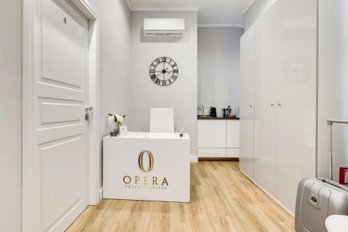 a white room with a door and a clock on the wall at Opera Private Suites by Premium Suites Collection in Rome