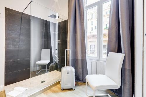 a room with two white chairs and a window at Opera Private Suites by Premium Suites Collection in Rome