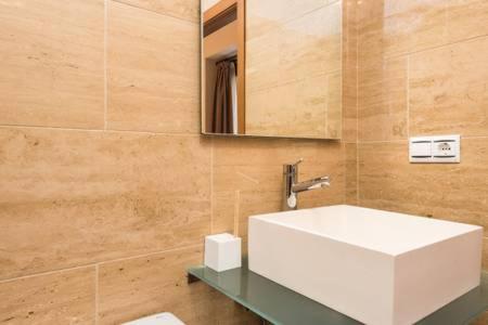 a bathroom with a white sink and a mirror at Apartment Villegas in Seville