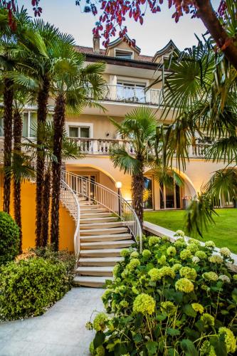 a building with stairs and palm trees at Villa Eden a member of Leading Hotels of the World in Merano