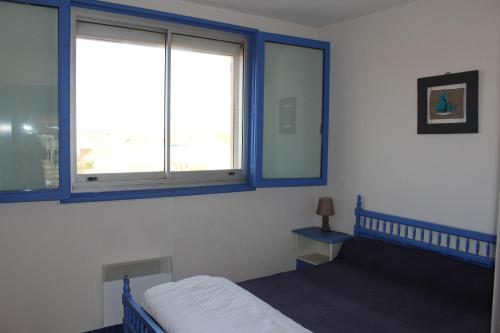 ポール・ラ・ヌーヴェルにあるGites de France Bleu à la merのベッドルーム1室(ベッド1台、窓2つ付)