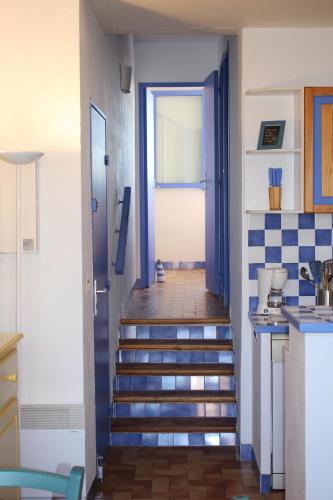 un couloir avec des escaliers menant à une porte dans l'établissement Gites de France Bleu à la mer, à Port-la-Nouvelle