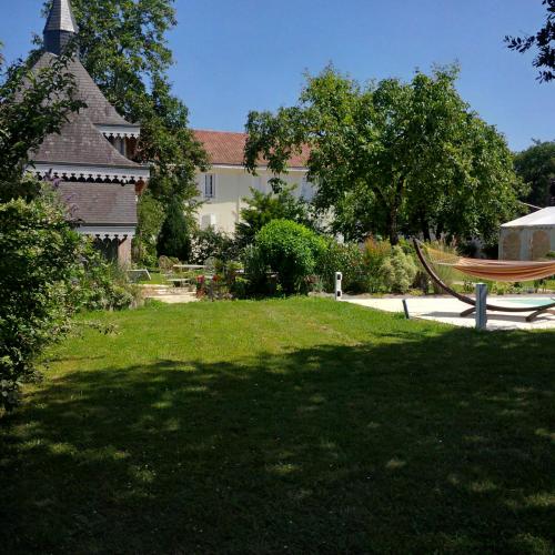 a large yard with a bench and a house at Maison d'Hôtes Lassaubatju in Hontanx
