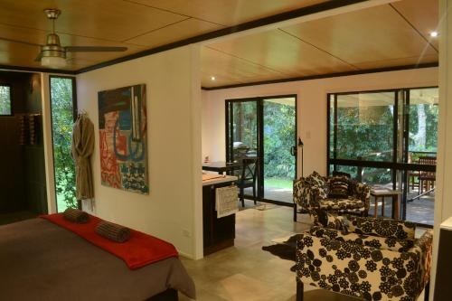 a bedroom with a bed and a desk and chairs at Wongari Eco Retreat in Lamington