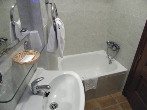 La salle de bains est pourvue d'un lavabo et d'une baignoire. dans l'établissement Casa Rural El Corralico, à Ribadelago