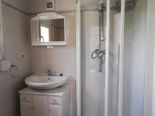 a white bathroom with a sink and a shower at Adel Locdenia in Els Poblets