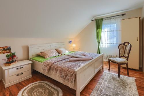 een slaapkamer met een groot bed en een stoel bij Apartment Mirjana in Kotor