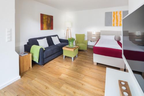 诺德奈Storchennest Norderney的配有床和沙发的酒店房间
