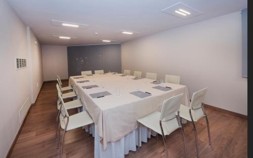 a conference room with a large white table and chairs at Barceló Ourense in Ourense