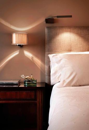 a bedroom with a bed and a night stand with a lamp at Hotel Rector in Salamanca