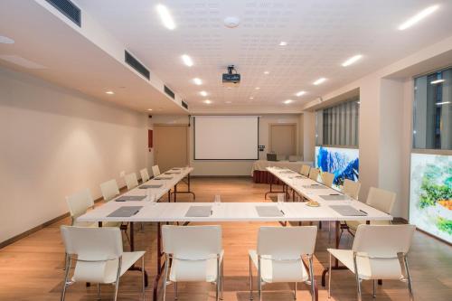 a conference room with tables and chairs and a whiteboard at Barceló Ourense in Ourense