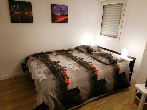 ein Schlafzimmer mit einem Bett mit einer Bettdecke darauf in der Unterkunft Le New York Bisontin in Besançon