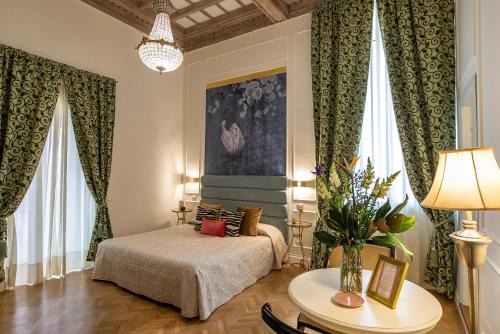ローマにあるイングラミ スイーツ アンド スパのベッドルーム1室(ベッド1台、テーブル、窓付)