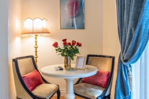 two chairs and a table with a vase of flowers at Ingrami Suites and Spa in Rome