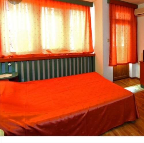 een slaapkamer met een bed met een oranje laken bij Studio Pipo in Varna