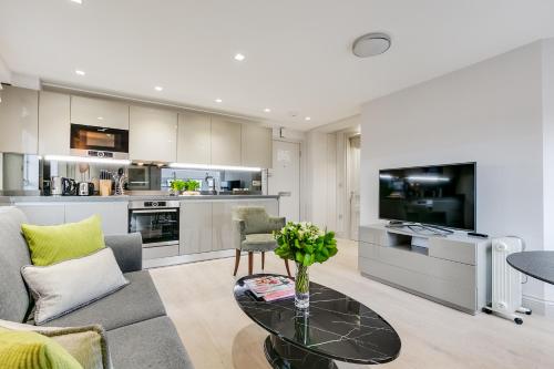 a living room with a coffee table and a kitchen at Nell Gwynn Chelsea Accommodation in London