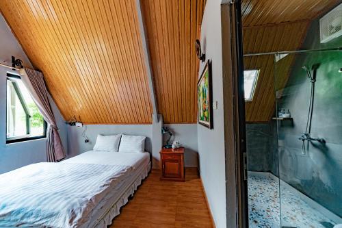 a small bedroom with a bed and a shower at Carambola Bungalow in Phong Nha