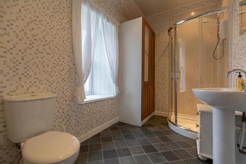 a bathroom with a toilet and a sink and a shower at The Trout Fly Guest House in Port Ellen