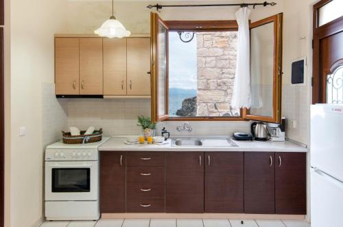 a kitchen with a sink and a window at Mermaid cottage in Longos
