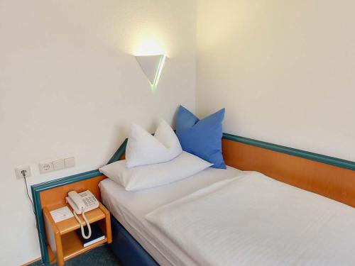 a room with a bed with a phone on a table at Hotel Empfinger Hof, Sure Hotel Collection by Best Western in Empfingen