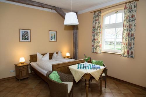 Schlafzimmer mit einem Bett, einem Tisch und einem Fenster in der Unterkunft Ostsee-Landhaus in Rerik