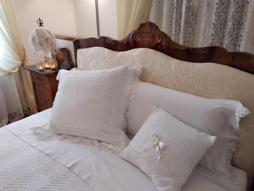 a white bed with white pillows and a wooden headboard at B&B Palazzo Mestichelli Boutique Palace in Monteprandone