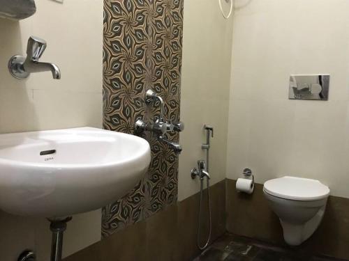 uma casa de banho com um lavatório e um WC em Saritas Guest House - Bogmalo Beach em Bogmalo