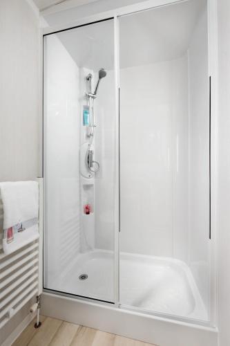a shower with a glass door in a bathroom at Roselands caravan park, Nr Lands End, Cornwall in St. Just