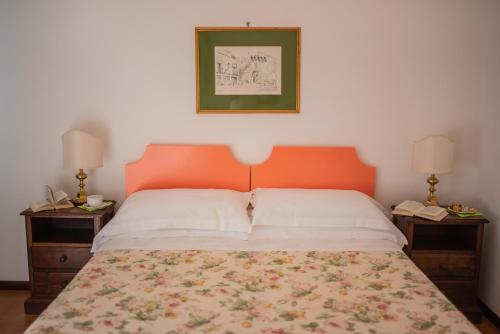 a bed with an orange headboard and two nightstandumentsuments at Hotel Villa Sirina in Taormina