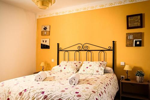 1 cama en un dormitorio con paredes amarillas en Casa Rural La Alegría de la Alcarria III, en Torremocha del Campo
